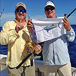 Captain George Poveromo and his angler hold up the release flag for their second Marlin caught on their Bimini trip aboard the Shadow Caster.